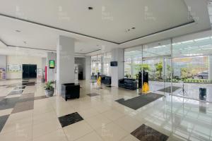 an empty lobby with glass walls in a building at RedLiving Apartemen Easton Park Jatinangor - Rajes Room in Sumedang