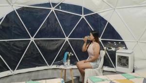 a woman sitting in a tent talking on a cell phone at San Miguel River Park (SMRP) Glamping 