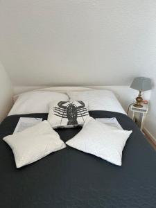 a bed with white pillows and a spider on it at Hummerstübchen Morsum in Morsum