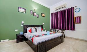 ein Schlafzimmer mit einem großen Bett mit grünen Wänden in der Unterkunft FabExpress Ashray in Noida