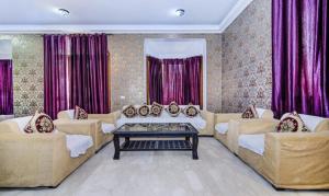 ein großes Wohnzimmer mit Sofas und einem Tisch in der Unterkunft FabExpress Ashray in Noida
