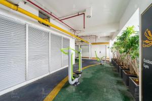 a corridor of a building with white doors and plants at RedLiving Apartemen Grand Kamala Lagoon - Icha Rooms Tower Barclay South with Netflix in Bekasi