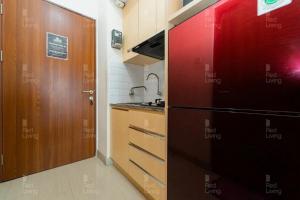 cocina con nevera negra y puerta en RedLiving Apartemen Grand Kamala Lagoon - Icha Rooms Tower Barclay South with Netflix, en Bekasi