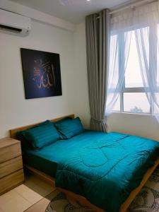 sypialnia z niebieskim łóżkiem i oknem w obiekcie Sofia Homes Kuala Terengganu w mieście Kuala Terengganu