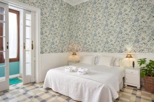 Un dormitorio con una cama blanca con toallas. en Hostal Poblenou en Barcelona