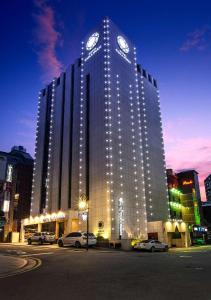 un grand bâtiment avec une horloge en haut dans l'établissement Hotel Cullinan Wangsimni, à Séoul