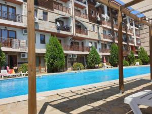 a hotel with a swimming pool in front of a building at MitProt ApartCompleks Panorama Bay 2 in Sveti Vlas