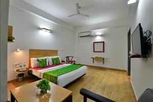 Habitación de hotel con cama y mesa en Divine Inn Couple Friendly Hotel near Sector 51 Metro Station, en Noida