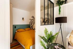 ein Schlafzimmer mit einem Bett mit einer gelben Decke in der Unterkunft « Kraou Kezeg » à 50m de la mer - 2/4 pers. in Saint-Malo