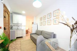 een woonkamer met een bank en een keuken bij Apartment Boliches by 10ToSea in Fuengirola
