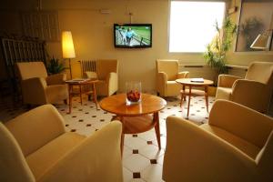 une salle d'attente avec des chaises, une table et une télévision dans l'établissement Hotel Bellavista, à Bellver de Cerdanya