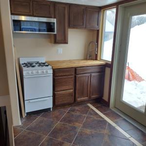 a kitchen with wooden cabinets and a stove top oven at Venture Gateway to National Parks & BYUI in Saint Anthony