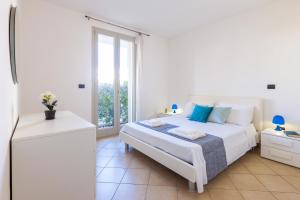 サンタ・マリア・アル・バーニョにあるLucrezia Apartments con Piscina nel cuore del Salentoの白いベッドルーム(ベッド1台、窓付)