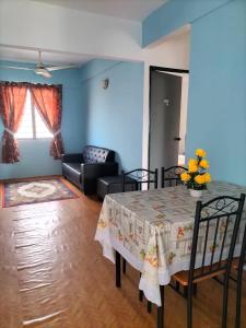 a living room with a table and a couch at KHAIRUL HOMESTAY PANGSAPURI SUTERA SEBERANG JAYA in Kampong Telok