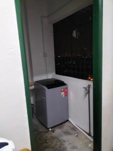 a room with a trash can in a room with a window at KHAIRUL HOMESTAY PANGSAPURI SUTERA SEBERANG JAYA in Kampong Telok