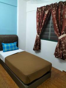 a bedroom with a bed and a window with curtains at KHAIRUL HOMESTAY PANGSAPURI SUTERA SEBERANG JAYA in Kampong Telok