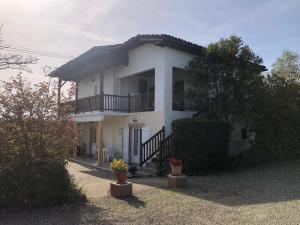 biały dom z balkonem i roślinami w obiekcie Le colibri w mieście Cazaubon