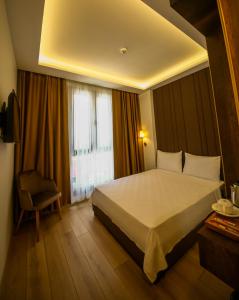 ein Hotelzimmer mit einem großen Bett und einem Stuhl in der Unterkunft ALKAN PALACE HOTEL in Kesan