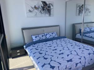 a bedroom with a bed with a blue comforter at Casino residence 2-BR ocean view in Gold Coast