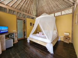 a bedroom with a bed with a mosquito net at Villa Bamboo in Gili Trawangan