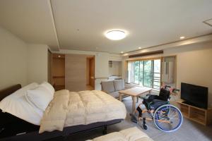 a bedroom with a bed and a wheelchair in it at Saito Hotel in Ueda