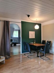 a dining room with a table and black chairs at Waldblick Ferienwohnungen in Bonndorf im Schwarzwald