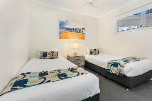 Llit o llits en una habitació de Raffles Mooloolaba