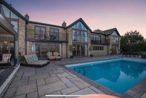 una casa con piscina frente a una casa en Poplars Cottage Luxury Detached Home With Outbuildings - Nr Bristol & Bath, 