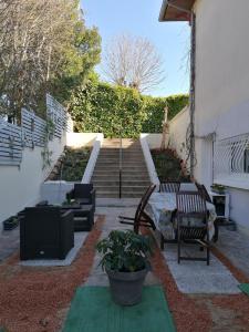 un patio con 2 sillas, una mesa y escaleras en Gite chez Pierrette en Valence-sur-Baïse