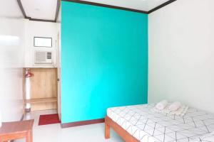 a bedroom with a green wall and a bed at LMIRAMARS Tourist Inn in Itaytay