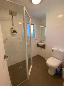 a bathroom with a toilet and a shower and a sink at Bimbimbie House Batemans Bay in Surf Beach