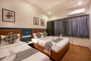 um quarto de hotel com duas camas e uma janela em Convastay Prestige- Near Apollo Hospital & US Consulate em Chennai