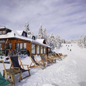 a group of chairs in the snow next to a ski lodge at Ljubica in Brzeće