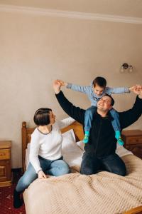 a man and woman sitting on a bed holding a child at Mountain Krystal in Bukovel +101 photos