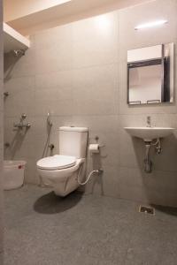 a bathroom with a toilet and a sink at Convastay Prestige- Near Apollo Hospital & US Consulate in Chennai