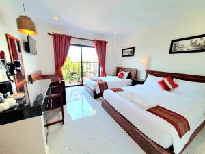 a hotel room with two beds and a balcony at Long Night Siem Reap Hotel in Siem Reap