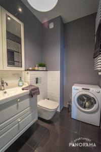 ein Badezimmer mit einem WC und einer Waschmaschine in der Unterkunft Apartament Panorama in Olsztyn