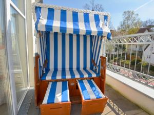 een blauwe en witte streepstoel op een balkon bij Dünenresidenz Königin Augusta - Apt. 09 in Binz