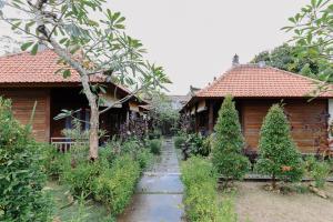 un jardín frente a dos casas de madera en The Lavana Jhonny Kibung Villas Lembongan, en Nusa Lembongan