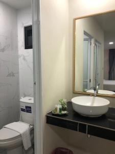 a bathroom with a sink and a toilet and a mirror at IM Residence Chiangmai in Chiang Mai