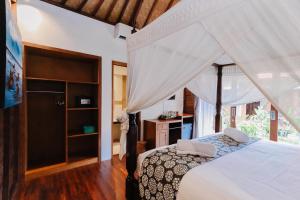 ein Schlafzimmer mit einem Himmelbett in der Unterkunft The Lavana Jhonny Kibung Villas Lembongan in Nusa Lembongan
