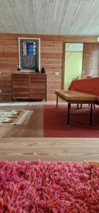 a living room with a table and a red rug at Chalet Yvonne in Borca di Cadore