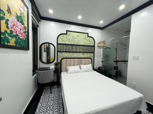 um quarto com uma cama branca e um espelho em Song Kim Hotel em Hai Phong