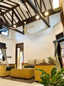 a living room with couches and a ceiling fan at Citrus-House com Hotel in Bogor