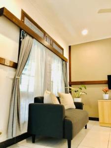 a living room with a couch and a window at Citrus-House com Hotel in Bogor