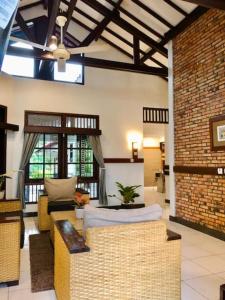 a living room with a couch and a brick wall at Citrus-House com Hotel in Bogor