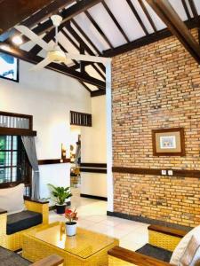 a large living room with a brick wall at Citrus-House com Hotel in Bogor