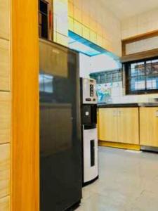 a kitchen with a black and white refrigerator at Citrus-House com Hotel in Bogor