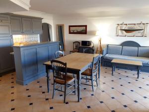 Una cocina y una sala de estar con una mesa y un sofá. en Ste Maxime T3 Terrasse vue mer et avec piscine, en Sainte-Maxime