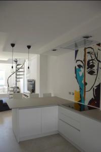 une cuisine avec des placards blancs et un tableau mural. dans l'établissement Deliziosa Villetta, à Termoli